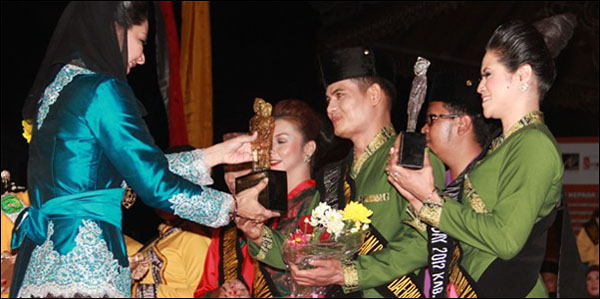 Bupati Rita Widyasari menyerahkan trofi kepada pasangan Adi Rifai-Aji Syarifah Hadijah dari BPKAD Kukar sebagai Juara I Lomba Busana Miskat