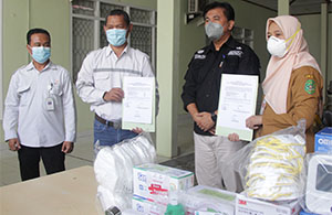 Aris Subagyo dan Kepala Dinkes Kukar menunjukkan berita acara penyerahan bantuan dari PT MHU kepada Dinkes Kukar