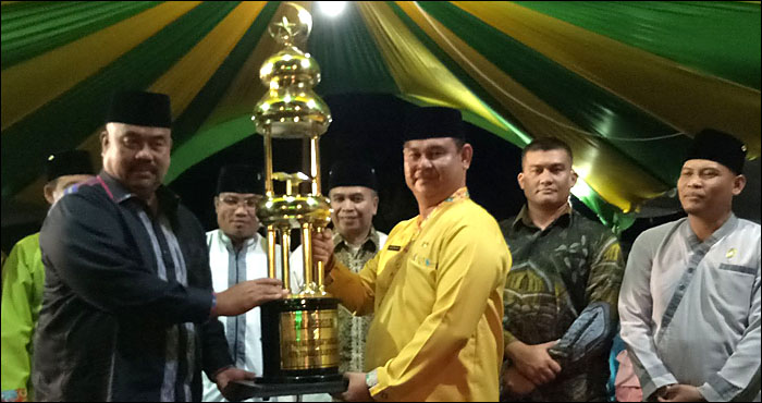 Plt Bupati Kukar Edi Damansyah menyerahkan piala bergilir Juara Umum MTQ kepada Camat Tenggarong, Janhariansyah