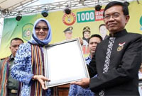 Bupati Rita Widyasari saat menerima piagam Rekor MURI untuk Bedah Rumah Terbanyak di Indonesia yang diserahkan Manager MURI Yusuf Ngadri