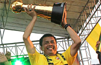 Jafri Sastra dengan bangga mengangkat Piala Jenderal Sudirman yang berhasil direbut Mitra Kukar pada Januari lalu