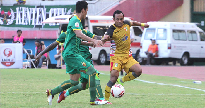 Gelandang Mitra Kukar, Atep, mencoba melewati hadangan dua pemain Sriwijaya FC