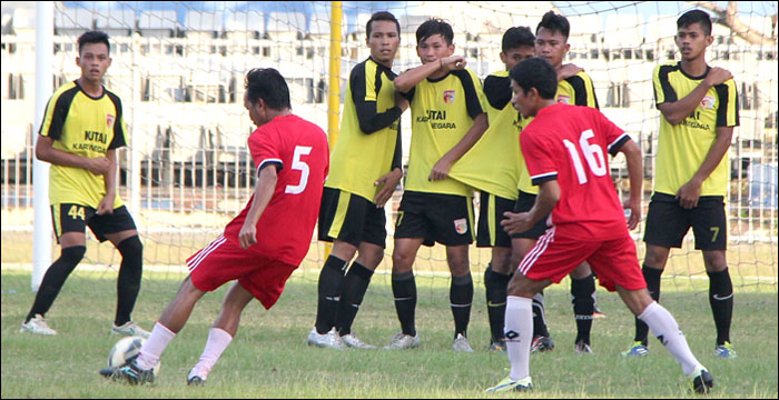 Pemain senior Junaidi Tagor (nomor 5 merah) dan Yance Katehokang (nomor 16 merah) dari tim GMC Samarinda saat menjajal para pemain seleksi Mitra Kukar U-21 dalam laga uji coba di Stadion Rondong Demang, Tenggarong