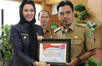 Bupati Rita Widyasari menyerahkan penghargaan kepada Camat Muara Jawa Safruddin