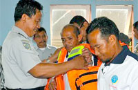 Kepala Dishub Kukar H Marsidik secara simbolis memasangkan pelampung kepada para peserta sosialisasi di Kecamatan Muara Kaman