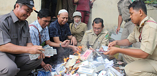 Camat Muara Muntai H Anjar Asmara (kedua dari kanan) bersama pemilik toko HM Nur (kopiah putih) serta tim pengawas peredaran makanan kadaluarsa dan bahan berbahaya wilayah hulu saat memusnahkan obat daftar G