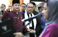 Kepala Disdukcapil Getsmani Zeth (kiri) saat mengucapkan sumpah jabatan yang dipandu Bupati Rita Widyasari