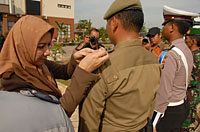 Bupati Rita Widyasari memasang pita tanda operasi kepada perwakilan Satpol PP Kukar