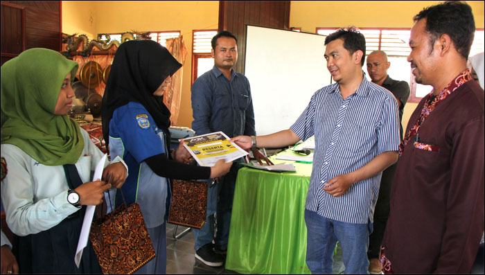 Ketua Panitia Bambang Irawan menyerahkan sertifikat pelatihan kepada siswi SMKN 2 Tenggarong, Andini Pradya Savitri, selaku Terbaik I Penulisan Berita