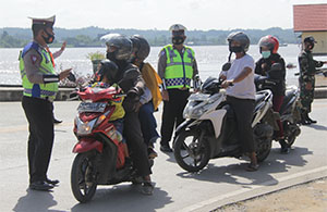 Petugas memeriksa para pengendara yang hendak masuk kota Tenggarong di KM 5