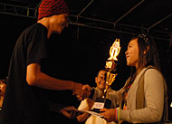 Anggota dewan juri Enda (kiri) menyerahkan hadiah Terbaik I kepada vokalis 