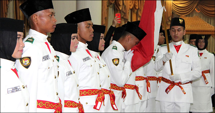 Anggota Paskibraka Kukar tahun 2017 secara bergantian mencium Sang Merah Putih pada upacara pengukuhan di Tenggarong, Rabu (16/08) malam