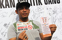 Ketua Bawaslu Kukar Muhammad Rahman menunjukkan sticker dan brosur yang dibagi-bagikan kepada warga Tenggarong di arena CFD
