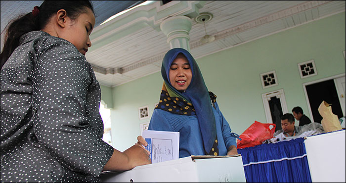 Salah seorang warga Tenggarong memasukkan surat suara yang telah dicoblos ke dalam kotak suara