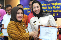 Deputi Pelayanan Publik Kementerian PAN RB Diah Natalisa menyerahkan penghargaan untuk DPMPTSP kepada Bupati Rita Widyasari
