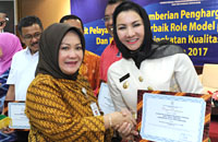 Deputi Pelayanan Publik Kementerian PAN RB Diah Natalisa menyerahkan penghargaan untuk DPMPTSP kepada Bupati Rita Widyasari