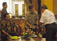 Pj Bupati Kukar H Sulaiman Gafur saat menerima buku laporan persiapan Pilkada Kukar 2010 dari Anggota KPU Kukar H Machlan Marwan
