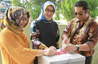 Bupati Rita Widyasari dan keluarga bersama-sama memasukkan surat suara ke kotak yang telah disediakan