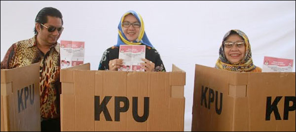 Bupati Kukar Rita Widyasari diapit sang suami, Endri Elfran Syafril, dan Ny Hj Dayang Kartini saat akan mencoblos di bilik suara