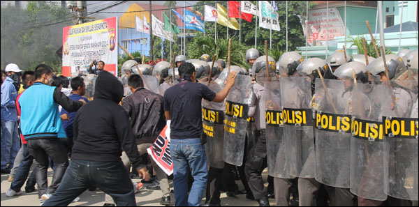 Petugas kepolisian membuat pagar betis untuk mencegah pengunjukrasa yang hendak memasuki gedung KPU Kukar, Tenggarong, Jum'at (13/06) kemarin