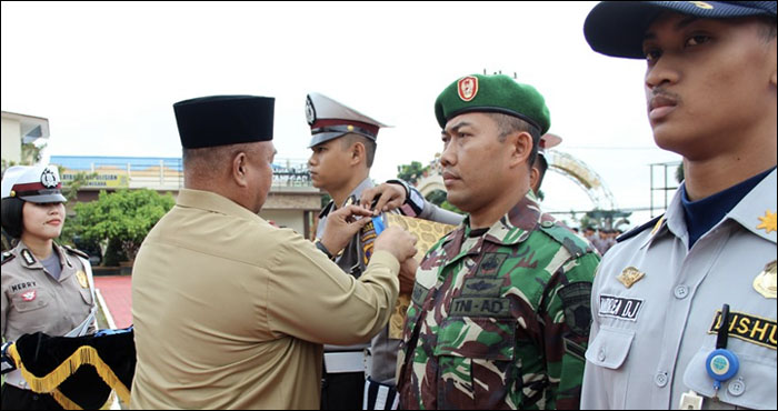 Wabup Kukar Edi Damansyah menyematkan pita tanda Operasi Ramadniya Mahakam 2017 kepada perwakilan peserta apel