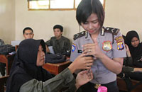 Salah seorang Polwan memeriksa ponsel milik siswi SMAN 2 Tenggarong
