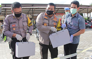 Kapolres AKBP Andrias Susanto Nugroho mencoba mengangkat barang bukti baterai yang beratnya lebih dari 40 kg