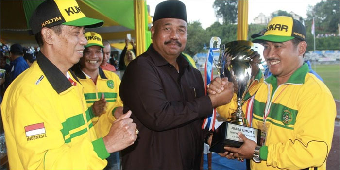 Wabup Kukar Edi Damansyah menyerahkan trofi tetap Juara Umum Popprov Kaltim XIV/2016 kepada pimpinan kontingen Kukar, Tulus Sutopo