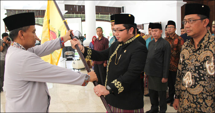 Petinggi Pore SK2 Sabran (kiri) menyerahkan bendera organisasi kepada AM Mirza Wardhana selaku Petinggi Wilayah SK2 Kaltim