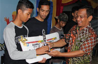 Wakil Kepala Sekolah SMK Farmasi Tenggarong Arifuddin Salam (kanan) menyerahkan hadiah kepada perwakilan SMPN 1 Tenggarong sebagai juara I Futsal SLTP