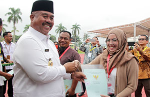 Bupati Kukar Edi Damansyah menyerahkan secara simbolis sertifikat tanah kepada salah seorang warga Loa Kulu