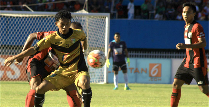 Penyerang Mitra Kukar Anindito Wahyu Erminarno menutup gerak pemain Persipura saat duel perebutan bola