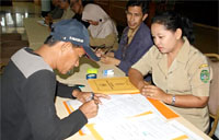Salah seorang warga Tanjong saat menandatangani berkas penyerahan penguasaan bangunan miliknya kepada Pemkab Kukar beberapa waktu lalu