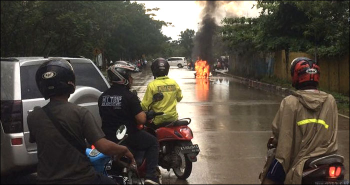 Para pengendara berhenti sejenak saat sepeda motor Honda Scoopy terbakar hebat di Jalan AP Mangkunegara, Tenggarong, Jum'at (24/03) sore