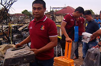 Seorang petugas Satreskrim Polres Kukar membawa salah satu barang bukti berupa kompor gas dari lokasi kebakaran