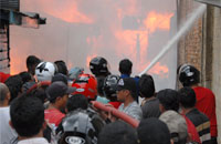 Petugas PMK dibantu masyarakat berupaya memadamkan api di mulut Gang 3