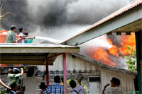 Petugas PMK dibantu warga berupaya memadamkan api yang berkobar hebat di rumah warga Gang 4 Jalan AM Sangaji, Tenggarong