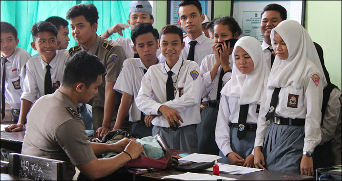 Anggota Polres Kukar menggeledah tas bawaan para pelajar di SMK YPK Tenggarong dalam razia yang digelar Rabu (05/10) pagi