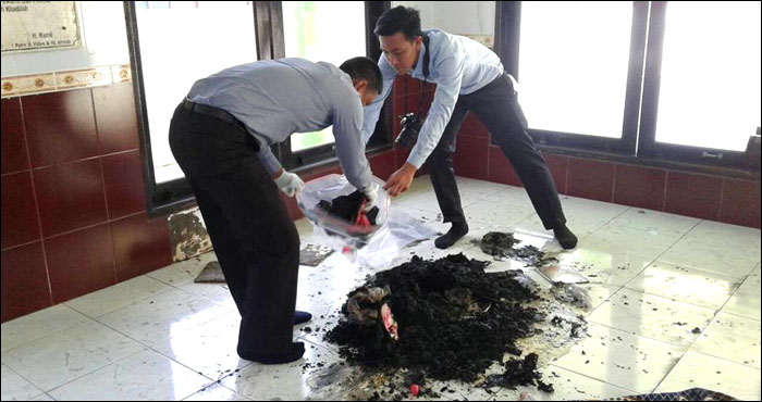 Petugas mengamankan barang bukti berupa bekas alat salat yang sebagian hangus terbakar