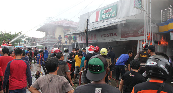 Petugas PMK dibantu para relawan dan masyarakat berupaya memadamkan api yang masih berkobar di bengkel Aljabar, Jalan Maduningrat, Tenggarong