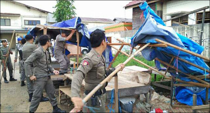 Petugas Satpol PP Kukar menertibkan lapak pasar tumpah di halaman gedung eks Bioskop Ratna, Tenggarong