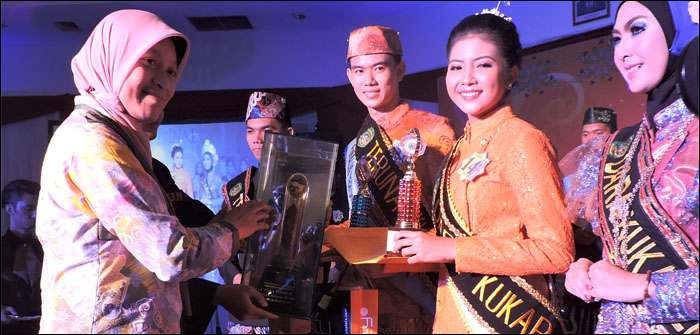 Kepala Disbudpar Kukar Sri Wahyuni menyerahkan piala bergilir Bupati Kukar kepada Shafira Wulan Fatima selaku Dara Kukar 2015