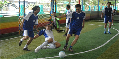 Tim wartawan (biru) berupaya mengamankan bola dari para penyerang tim futsal Departemen Komunikasi Total E&P Indonesie