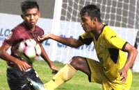 Striker Mitra Kukar U-19 Agus Santosa berusaha melewati hadangan pemain PSM U-19