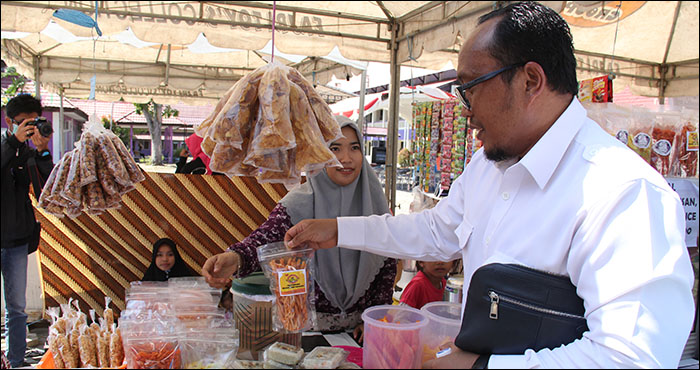 Rektor Unikarta Erwinsyah mengamati produk-produk yang dijual salah satu stan Festival FEBIS Unikarta, Selasa (09/04) pagi