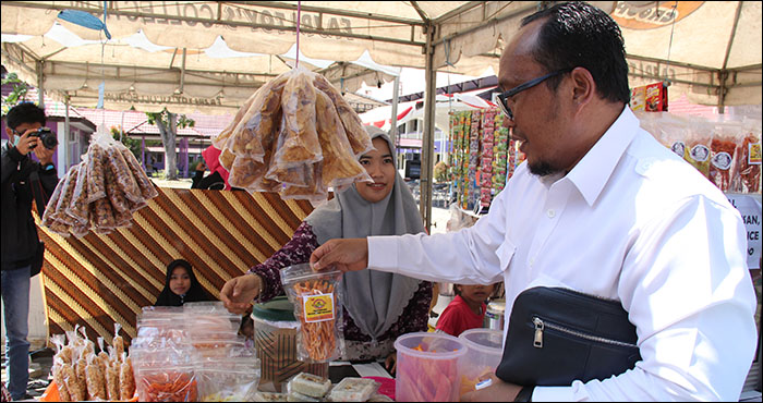 Rektor Unikarta Erwinsyah mengamati produk-produk yang dijual salah satu stan Festival FEBIS Unikarta, Selasa (09/04) pagi
