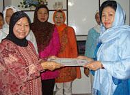 Dayang Safiah Alwi (kiri) menerima surat pelimpahan tugas dari ketua lama Hj Farida Samsuri