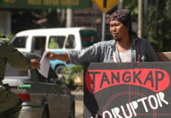 Buyung Marajo membagikan selebaran kepada para pengguna jalan