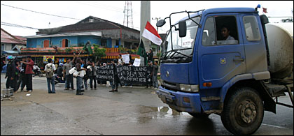 Sebuah mobil tangki BBM melintas di depan aksi unjuk rasa Aliansi Mahasiswa Peduli Rakyat di Tenggarong. Mulai 1 Juni 2008, pemerintah akan menaikkan harga BBM