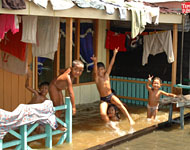 Anak-anak Tanjong dengan suka cita bermain air didepan rumah mereka yang terendam air